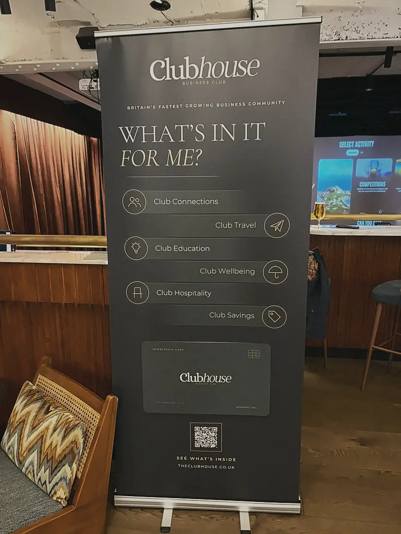 The Clubhouse banner beside a golf simulator bay at Pitch